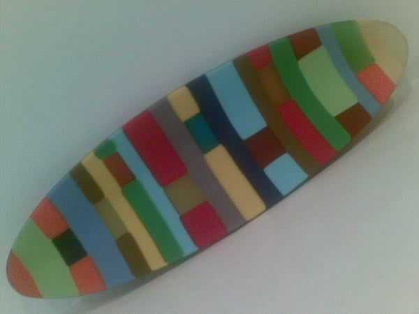Colorful surfboard-shaped object with striped patternColorful patterned surfboard on a white background