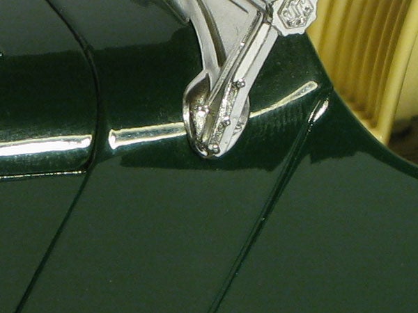 Close-up photo of a green surface with a metallic clip.Close-up photo showcasing Canon PowerShot G9's macro capabilities.