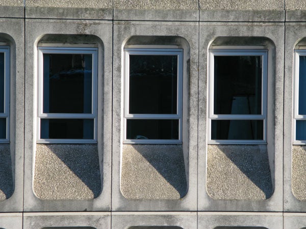 Building facade with geometric window pattern, possibly taken with Canon PowerShot G9.Concrete building facade with patterned windows.