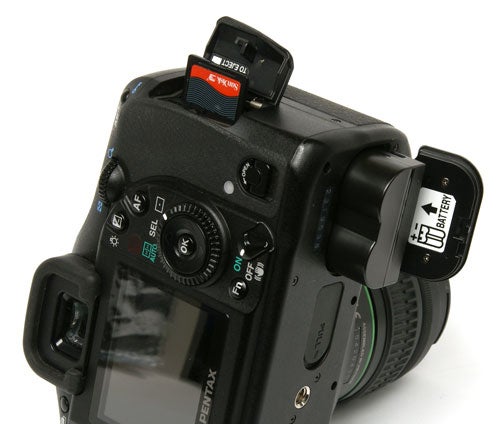 Pentax K10D DSLR camera with open memory card slot.Pentax K10D DSLR camera showing buttons and dials.