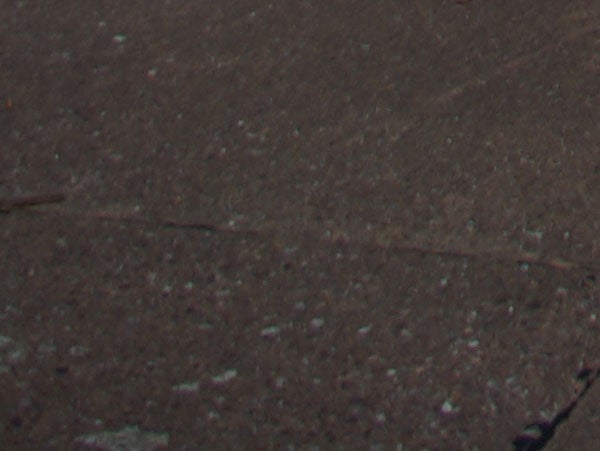 image of a textured surface with no clear subject.texture surface, possibly low-light camera test shot.