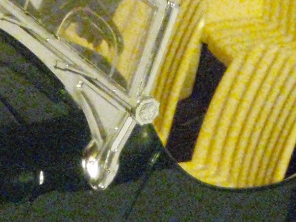 Low-resolution photo of a clear glass object against a patterned background.Close-up of Olympus mju 790 SW camera under water.