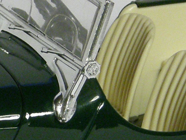 Close-up of a metallic car part with green detailsClose-up of classic car hood and ornament.
