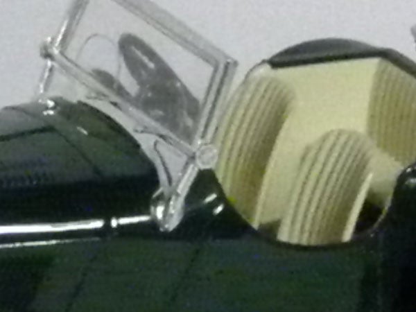 Close-up of a toy car with open door and detailed interior.Close-up of a green toy car with open doors.