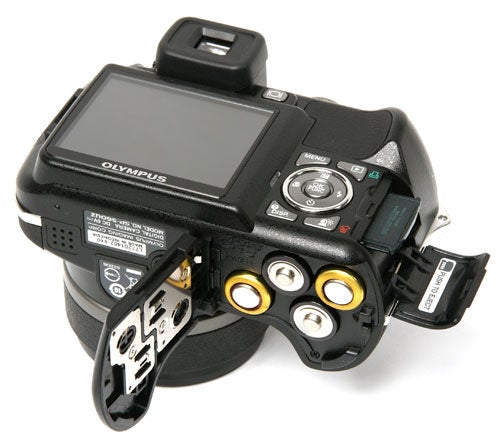 Olympus SP-560UZ camera with open battery compartment.