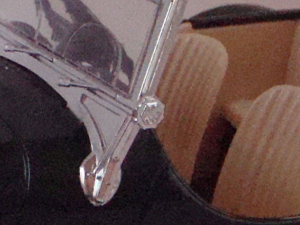 Close-up of shiny glasses hinge and partial frame.
