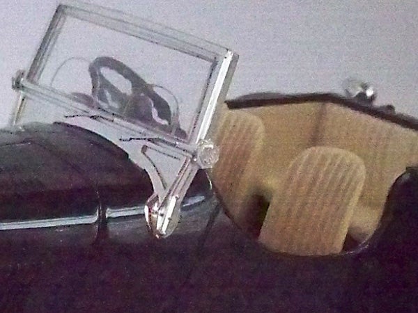 Grainy photo of sunglasses and a watch on a table.photo of glasses and a wooden object.