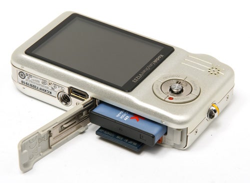 Kodak EasyShare V1233 camera with open battery compartment.