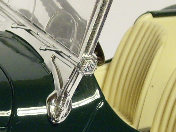 Close-up of a vintage car's windshield wiper and chrome detailing.