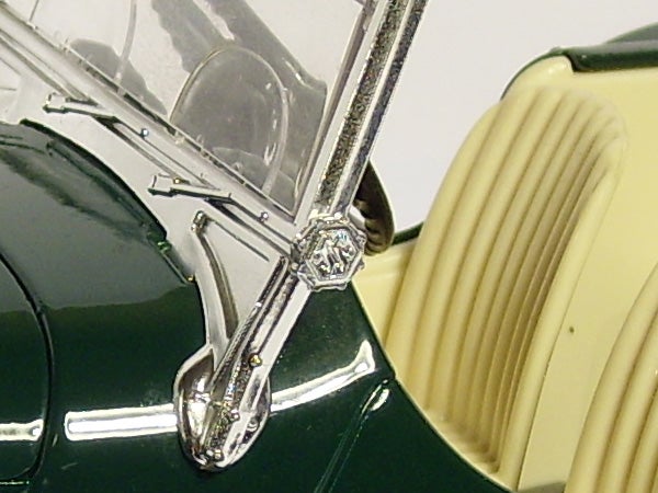 Close-up of a green vintage car model's windshield and wiper