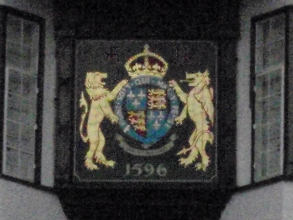 photo of a crest with lions and a crown dated 1596.photo of an emblem with lions and a crown, dated 1596.