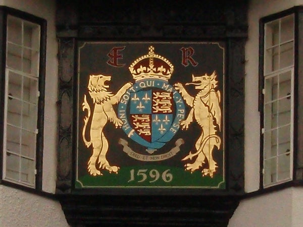 Coat of arms plaque on building facade with date 1596Historic crest on a building with lions and a date of 1596.