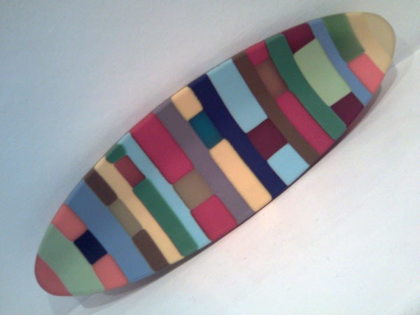 Colorful abstract pattern on a surfboard-shaped object.Colorful abstract patterned surfboard on a white background.