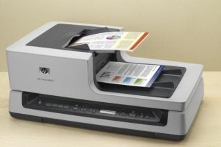 HP ScanJet N8460 scanner with documents on feeder.
