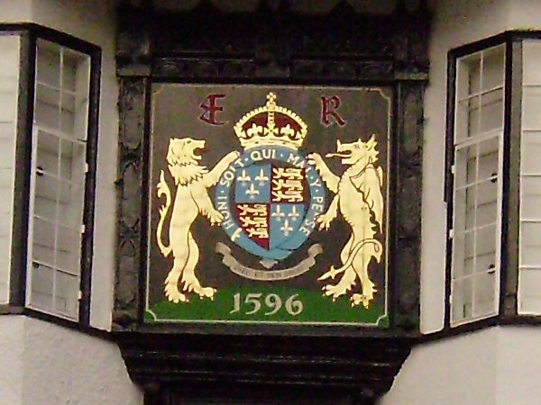 Ornate coat of arms with lions and a crest from 1596.Coat of arms with lions and crown on a building, dated 1596.
