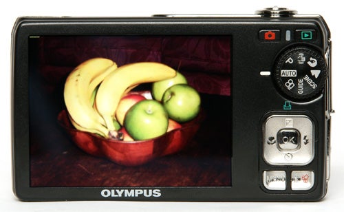 Olympus FE-290 camera displaying fruit bowl image on screen.