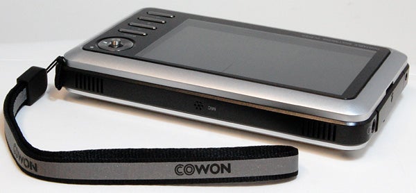 Cowon A3 30GB portable multimedia player on table with wrist strap.Cowon A3 30GB portable multimedia player on white background.