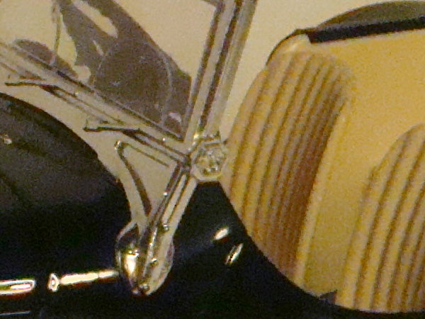 Close-up of chrome motorcycle parts and yellow seat.Close-up of a camera lens and blurred background.