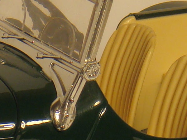 Close-up of a vintage car's chrome side mirror and yellow seat.Close-up of a camera's lens and aperture mechanism.