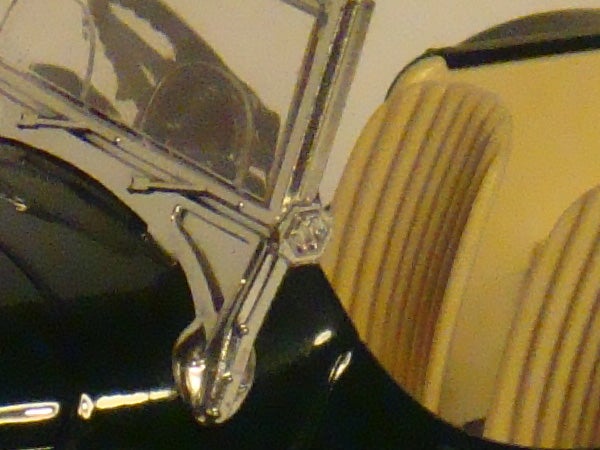 Close-up of vintage car showing chrome details and headlights.Close-up of a classic car's shiny chrome side mirror and details.