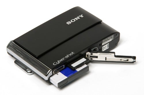 Sony Cyber-shot DSC-T70 camera with sliding cover open.Sony Cyber-shot DSC-T70 camera with open battery compartment.