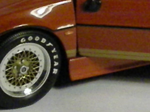 Close-up of a toy car wheel and side panel.