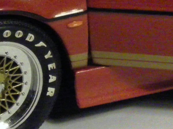 Close-up of a model car tire and side panel.
