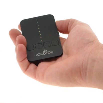 Hand holding a Loc8tor Lite tracking device.