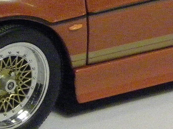 Close-up of orange car wheel and door details.