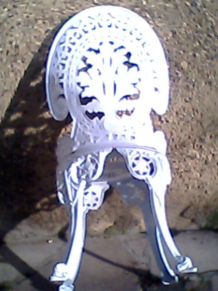 White ornate metal chair in outdoor setting