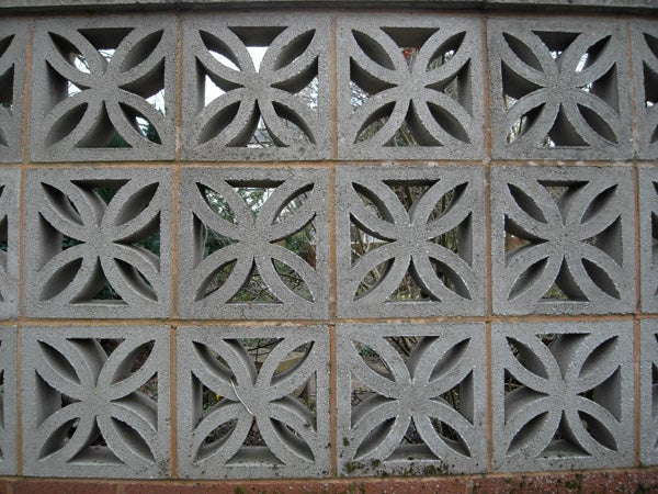 Decorative concrete block wall with leaf patterns.