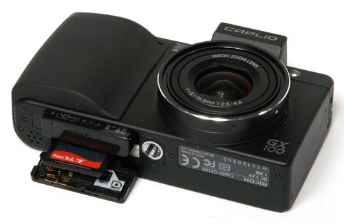 Ricoh Caplio GX100 camera with open memory card slot.
