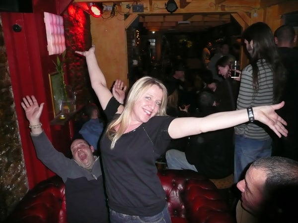 Woman and man celebrating joyfully in a crowded bar.