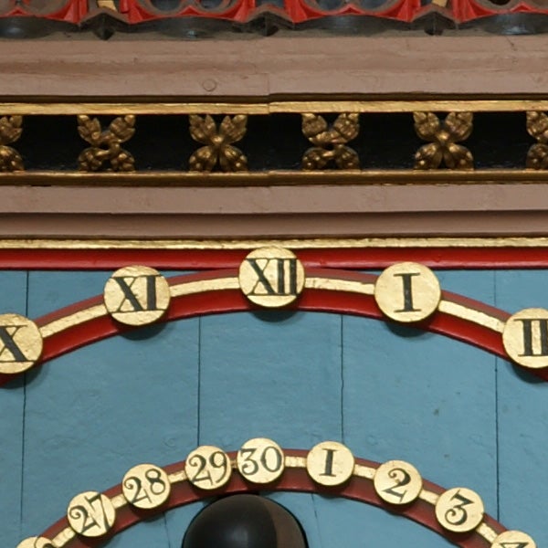 Close-up of an ornate clock face with roman numerals.