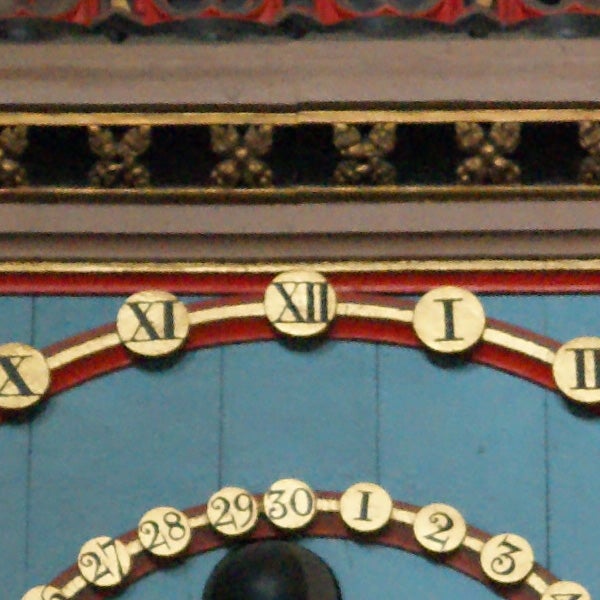 Close-up of an ornate clock face with Roman numerals.
