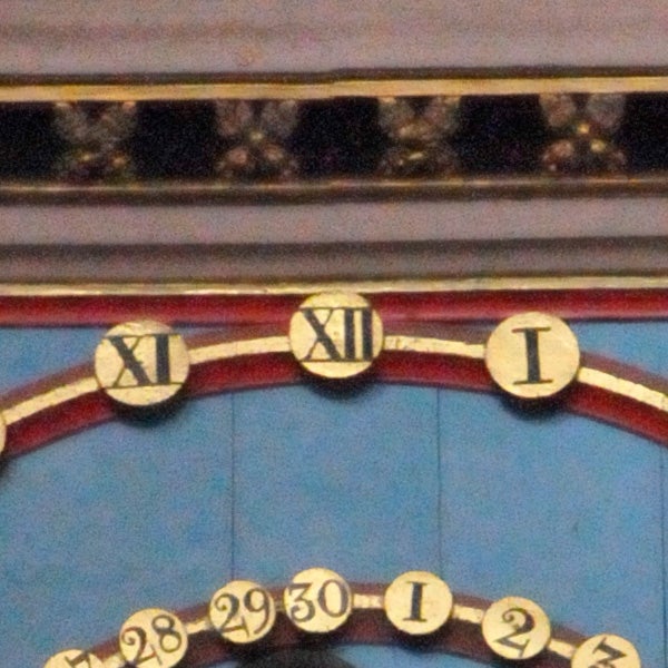 Close-up photo of a clock face with roman numerals.