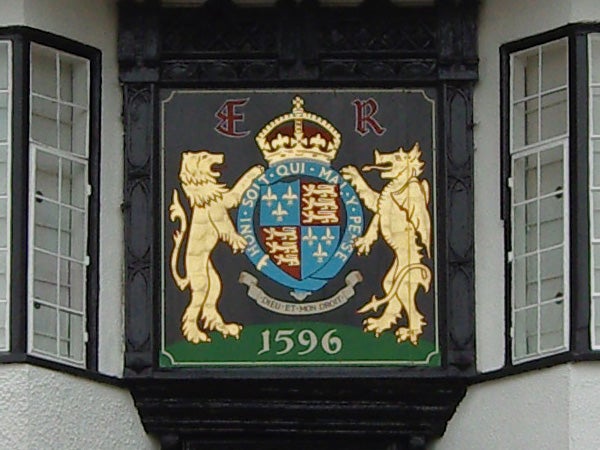 Coat of arms with lions and a crown on an exterior wall.
