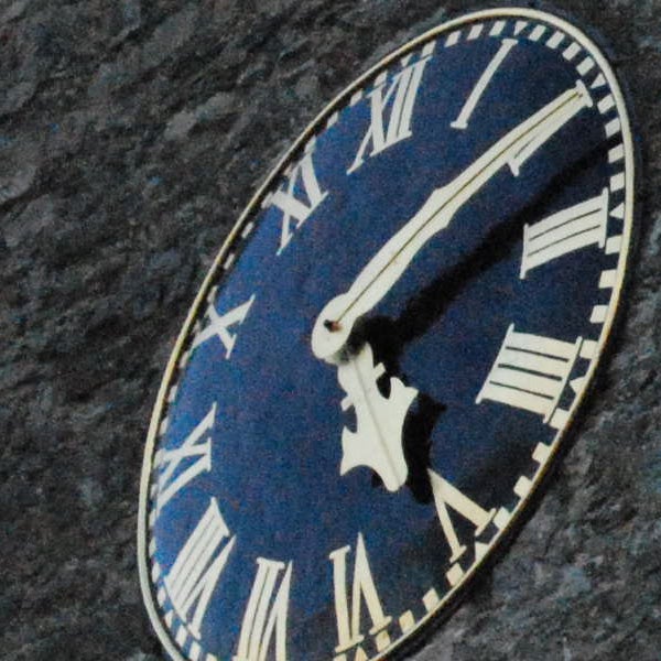 Close-up of an oval clock face with Roman numerals.Close-up of a clock face with Roman numerals.