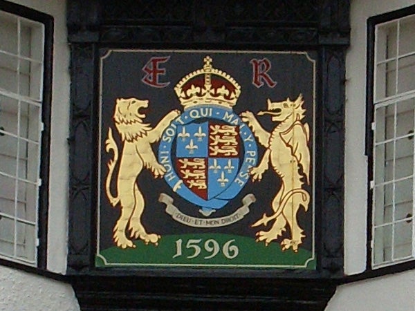 Coat of arms with lions and a crown on a building plaque from 1596.Coat of arms with lions and motto displayed on a plaque.