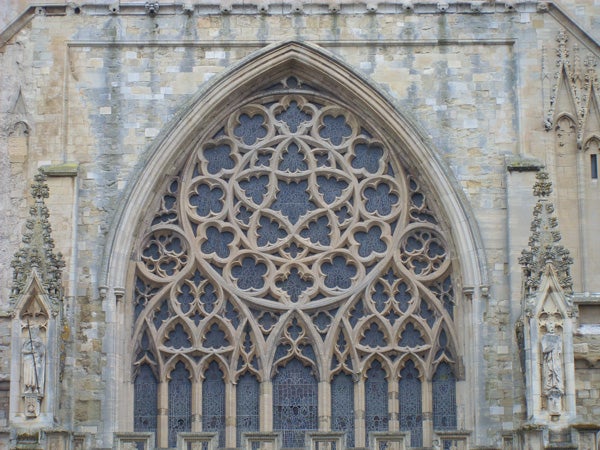 Intricate stone window design on gothic cathedral facadeIntricate stone window architecture on historical building facade.