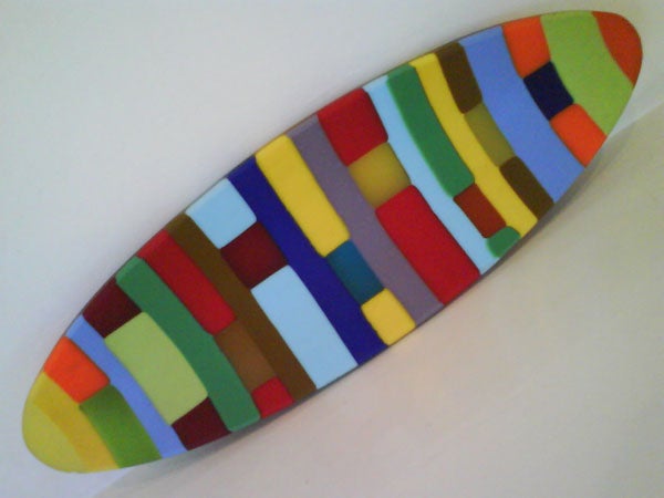 Colorful patterned surfboard-like object on white background.Colorful abstract geometric pattern on a surfboard-shaped object.