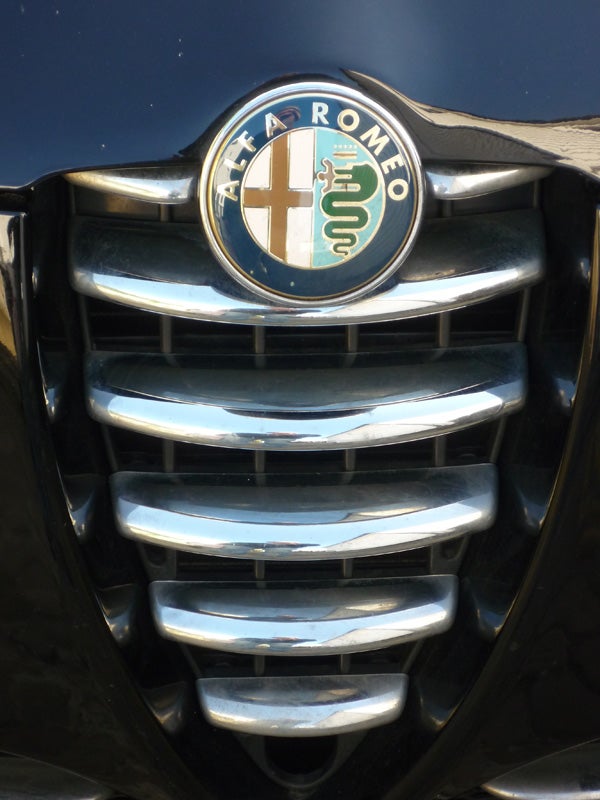 Close-up of an Alfa Romeo car grille and logo.Close-up of an Alfa Romeo car grille and emblem.