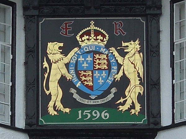 Historic crest with lions and a crown displayed on a building.Historic crest with lions and a crown on a building plaque.