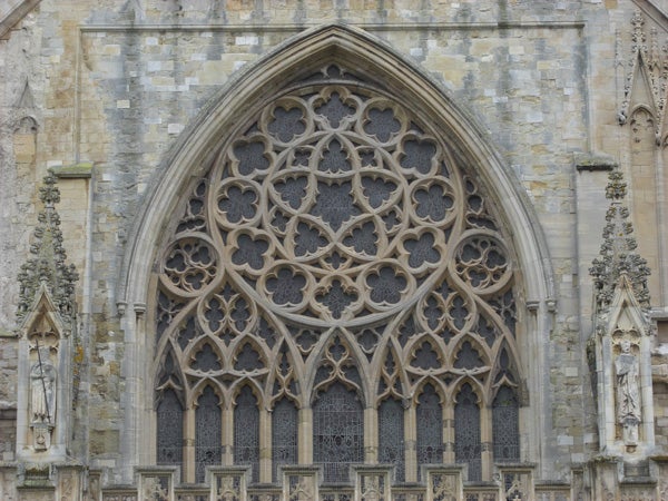 Intricate gothic window architecture on church facade.Intricate Gothic window architecture on a stone church facade.