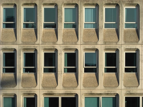 Pattern of windows on a concrete building facade.Facade of a building with repetitive windows and balconies.