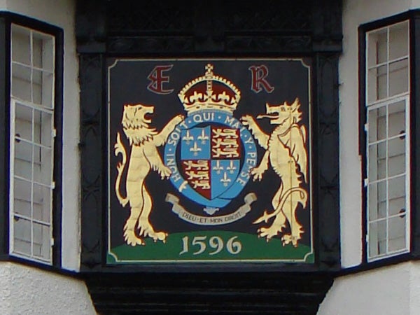 Detailed heraldic crest on building with date 1596.Photo of a crest with lions and a crown, dated 1596.