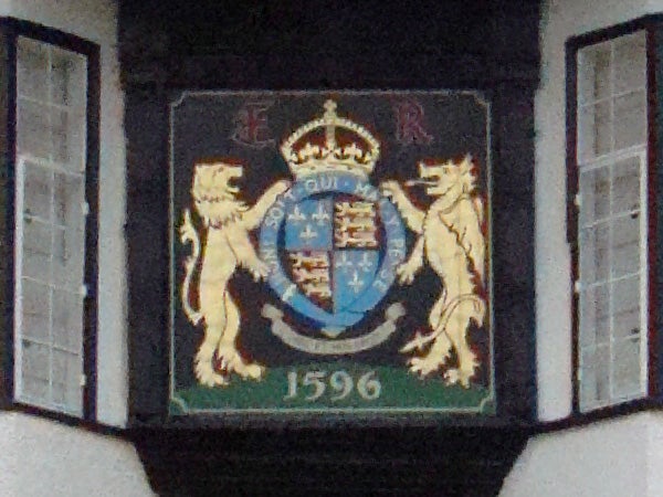 Coat of arms plaque with date 1596 on building facade.Decorative crest with lions and a shield, dated 1596.