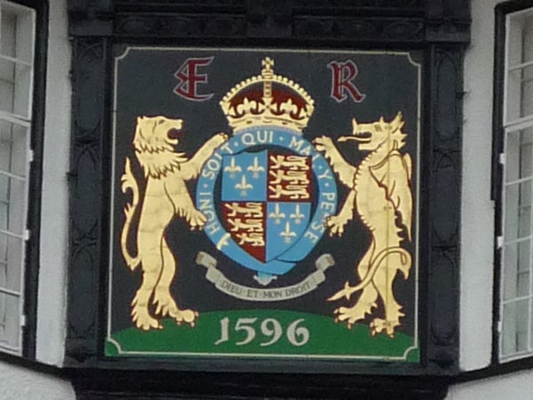 Historical coat of arms on a building from 1596.Ornate coat of arms with lions and a crown, dated 1596.