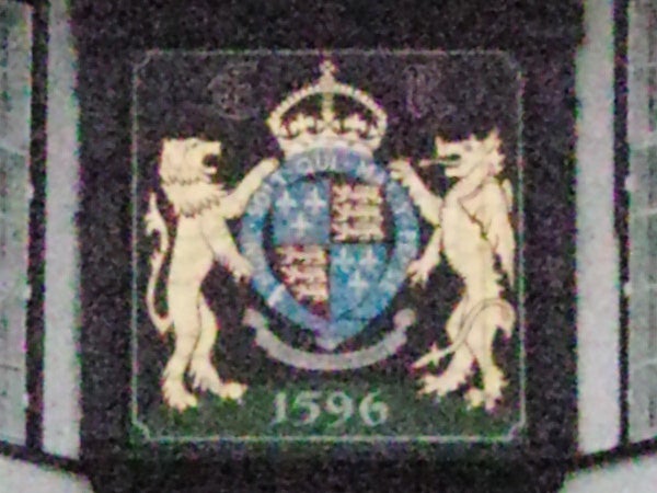 photo of an emblem with lions and a shield.Close-up of a postage stamp with heraldic design.
