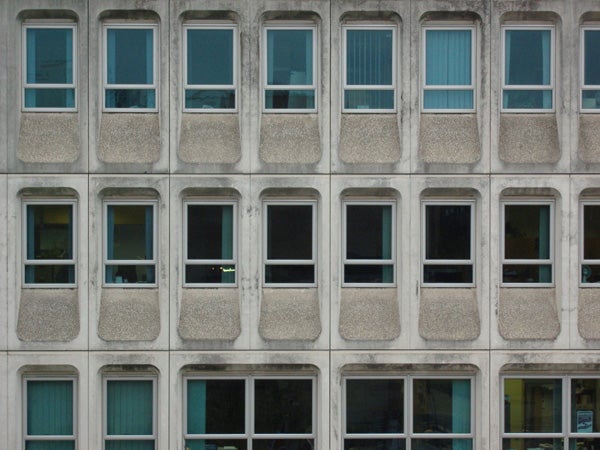 Patterned building facade with multiple windows.Facade of building with repetitive windows pattern.